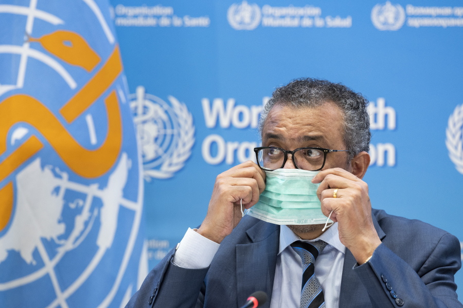 FILE - Tedros Adhanom Ghebreyesus, Director General of the World Health Organization (WHO), removes his protective face mask prior to speaking to the media regarding the coronavirus COVID-19 and WHO's global health priorities in 2022, during a new press conference, at the World Health Organization (WHO) headquarters in Geneva, Switzerland, Monday, Dec. 20, 2021. Ghebreyesus has laid out his plans and goals to further fight the coronavirus and other priorities as he pitched his case for a new five-year term. It came as he has faced criticism from the government of his own country Ethiopia over his comments about the embattled Tigray region. Tedros is running unopposed for a second five-year term that he is all but certain to win at the WHO's annual assembly in May.