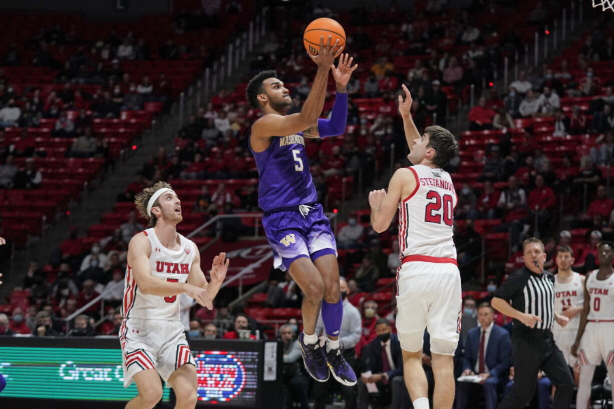 Washington guard Jamal Bey (5) goes to the basket as Utah guard Lazar Stefanovic (20) defends during the first half of an NCAA college basketball game Thursday, Jan. 6, 2022, in Salt Lake City.