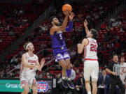 Washington guard Jamal Bey (5) goes to the basket as Utah guard Lazar Stefanovic (20) defends during the first half of an NCAA college basketball game Thursday, Jan. 6, 2022, in Salt Lake City.