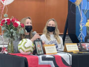 Hockinson senior Ellie Ritter, left, speaks to the crowd at the school?s signing day, while twin sister Kylie Ritter, right, looks on Wednesday at Hockinson High School. Ellie will attend Northwest Nazarene University to play soccer and Kylie is headed to George Fox University to play basketball.