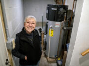 Toni Walker stands next to her heat pump water heater in her home Jan. 18 in Monroeville, Pa.