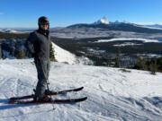 Tony Barnes, of Vancouver, gets ready to ski from the top of Hoodoo with Mount Washington and the Three Sisters in the background on Jan. 16.
