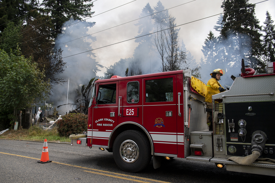Firefighter Kevin Saari of Clark-Cowlitz Fire Rescue helps battle the blaze at the Old Cherry Grove Church property near Battle Ground in July 2021.