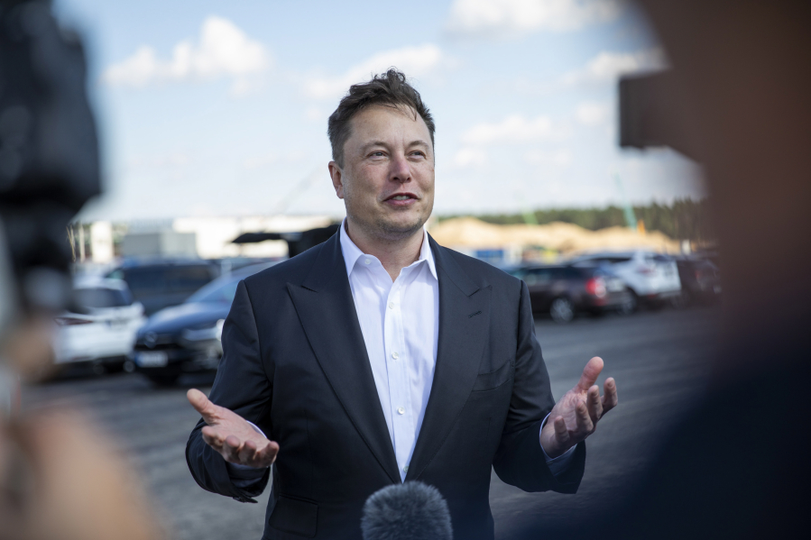 In this file photo, Tesla head Elon Musk talks to the press as he arrives to to have a look at the construction site of the new Tesla Gigafactory near Berlin on September 3, 2020 near Gruenheide, Germany. Tesla is moving its headquarters from California to Texas, one of several prominent tech companies to do so.
