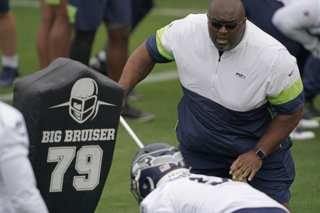 Seattle Seahawks defensive line and assistant head coach Clint Hurtt, right, runs a drill during NFL football practice Tuesday, June 15, 2021, in Renton, Wash. (AP Photo/Ted S.