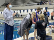 Battle Ground?s Carsten Hicks is all smiles after receiving the sixth-place medal in the 100 butterfly from Battle Ground coach Trisha Hicks at the 4A boys state swimming championships on Saturday in Federal Way.