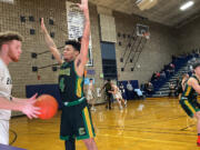 Evergreen’s Delo Doutrive (4) defends an Arlington inbounds pass during Tuesday’s regional play-in game at Arlington.