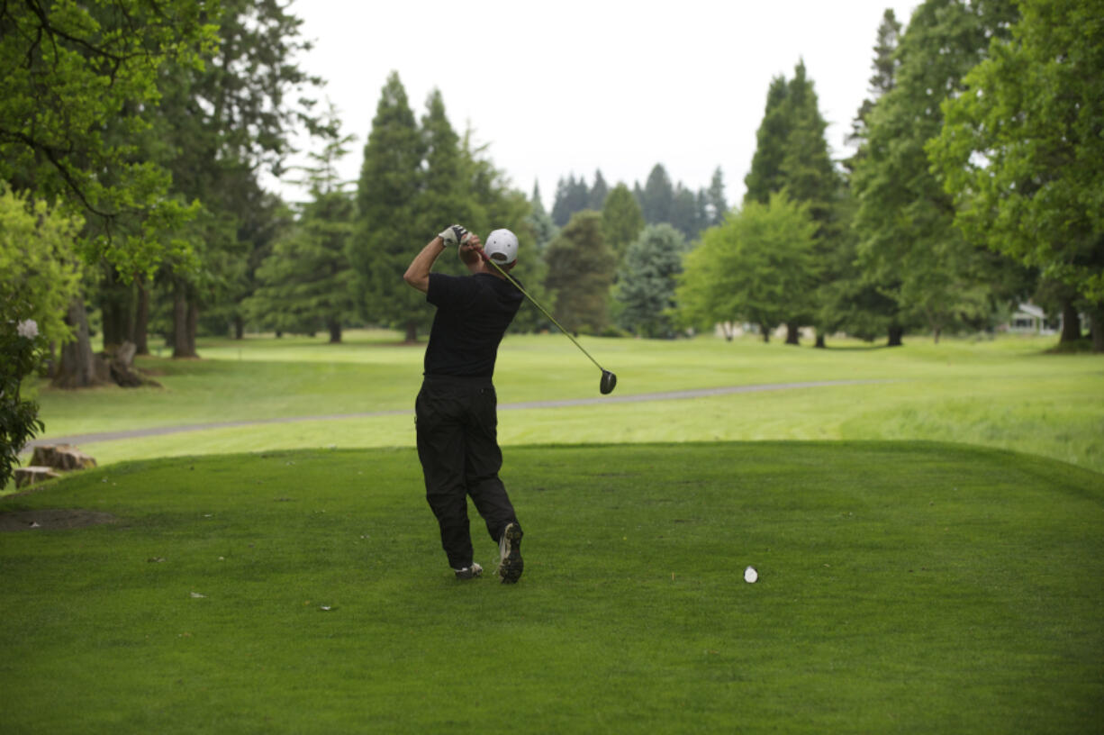 A golfer plays a round at Club Green Meadows golf course. The club is for sale, but the sellers wish for the golf course to remain.