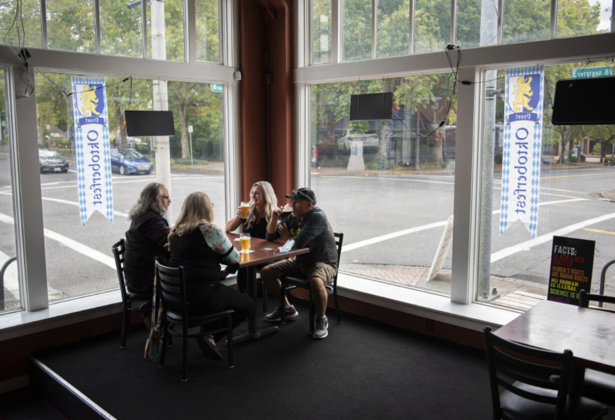 Craig Miller, from left, his wife Laurie, both of Salem, Ore., and Jennifer Miller and her husband Scott, both of West Linn, Ore., enjoy beers together at Trusty Brewing Co. in Vancouver in September 2020. Trusty Brewing is for sale because the owner needs to care for a family member experiencing medical issues.