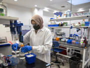 Riffat Ahmed checks the quality of samples in Capsigen's downtown Vancouver lab. At top, AAV capsids have the potential to deliver gene therapy tools directly to specific cells to cure diseases that currently have no cure.