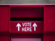 Voters stop by the Fisher's Landing ballot drop-off box Monday.