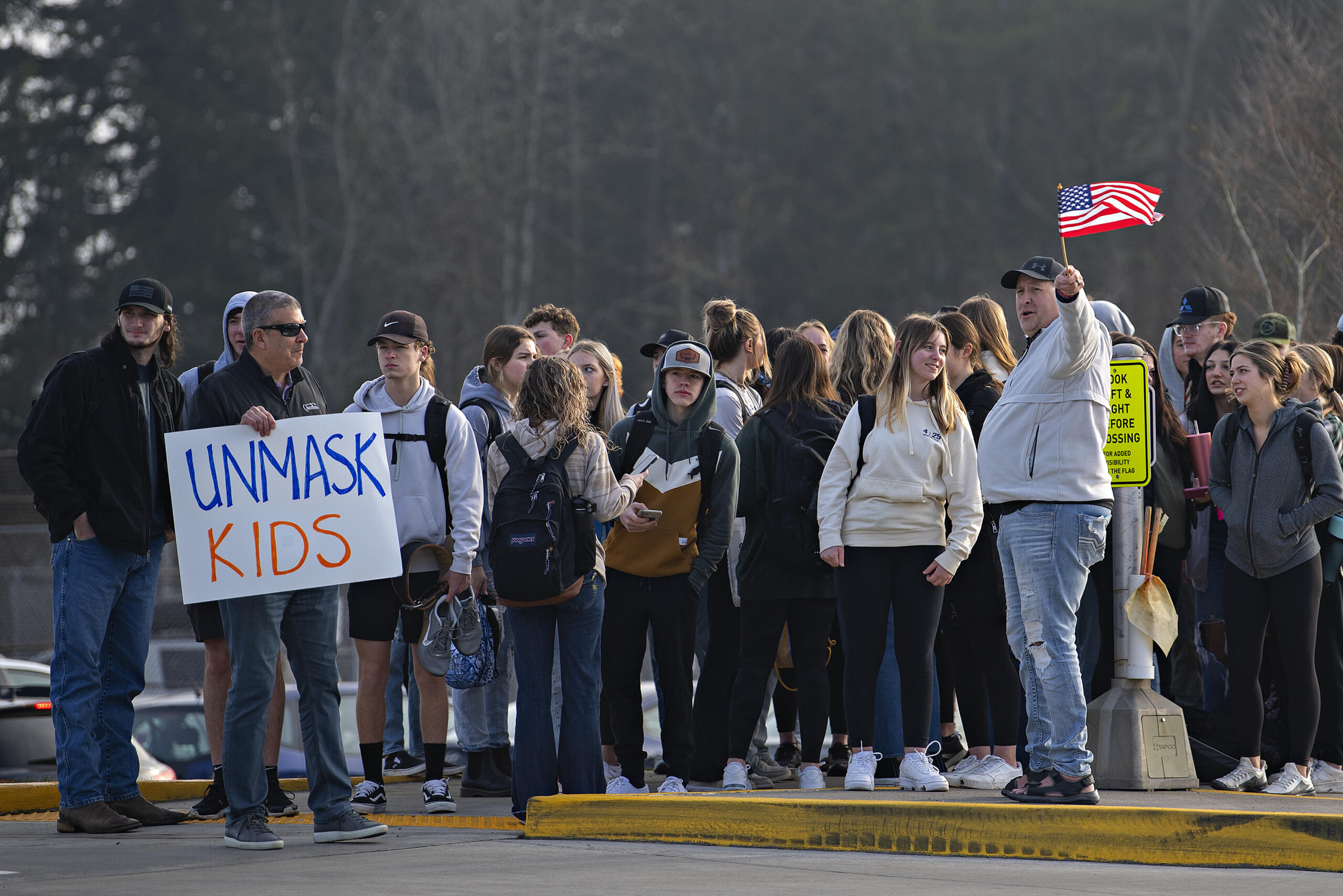 Students join a small group of protesters as they walk out of class while demonstrating against mandatory masks in schools outside Ridgefield High School on Wednesday morning, Feb. 9, 2022.