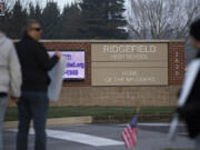 A small group of protesters gathers outside Ridgefield High School to protest mandatory masks in school Wednesday morning.