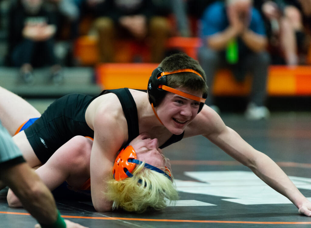Washougal's Ryan Langston looks toward his coaches for direction as he nears a pin of Ridgefield's Drevon Cooper in the 2A Region 3 Wrestling Tournament on Saturday, Feb. 12, 2022, at Washougal High School.
