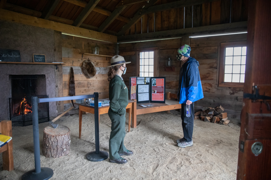 Park Ranger Justine Hanrahan, left, welcomes Jim Stenlund of Vancouver to a reconstructed house at the Fort Vancouver village on Saturday. "Every time I come out here, I learn something new," said Stenlund, who walks at Fort Vancouver daily.