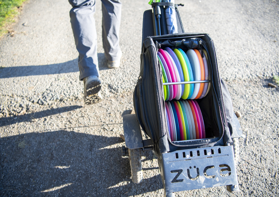 Josh Dearing of Vancouver wheels a bag of disc golf equipment around at Hockinson Meadows Community Park. A new 18-hole course is expected to begin construction at the park by May.