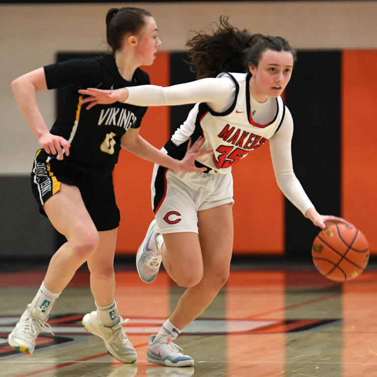Camas freshman Keirra Thompson, right, fends off Inglemoor junior Dulcy Solomon on Friday, Feb. 25, 2022, during the Papermakers’ 56-44 playoff win against Inglemoor at Battle Ground High School.