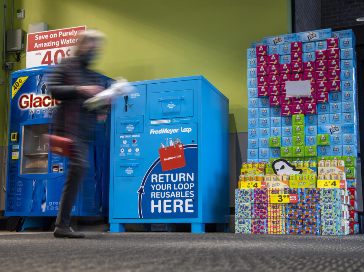 A shopper walks in front of a Loop return bin Tuesday at the Grand Central Fred Meyer. The company is partnering with Loop, which offers reusable packaging for select groceries.