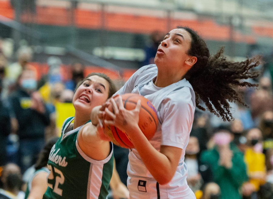 Port Angeles' Eve Burke tries to swipe the ball from the strong grasp of Hudson's Bay's Mahaila Harrison in a WIAA State Regional basketball game on Saturday, Feb. 26, 2022, at Battle Ground High School.