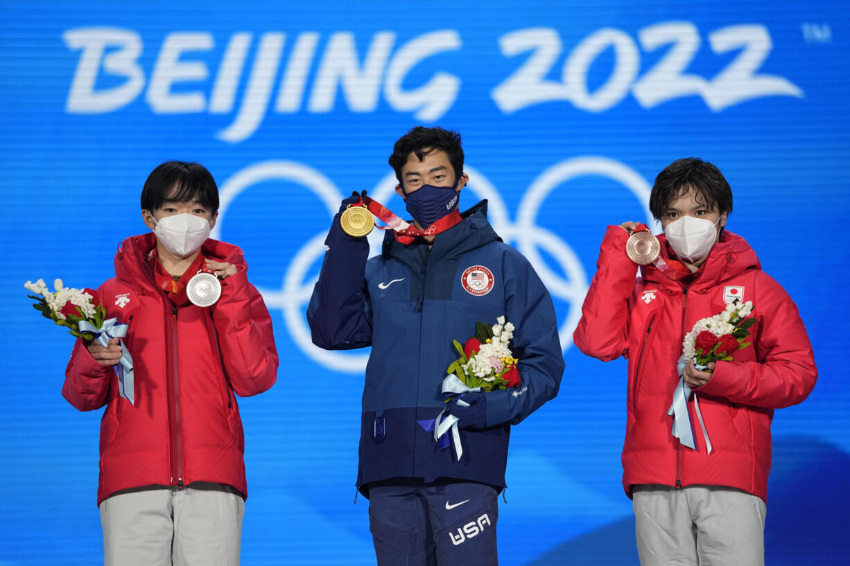 From left, silver medalist Yuma Kagiyama of Japan, gold medalist Nathan Chen of the United States and bronze medalist Shoma Uno of Japan celebrate during the medal ceremony for the men's free skate figure skating at the 2022 Winter Olympics, Thursday, Feb. 10, 2022, in Beijing. (AP Photo/Jae C.