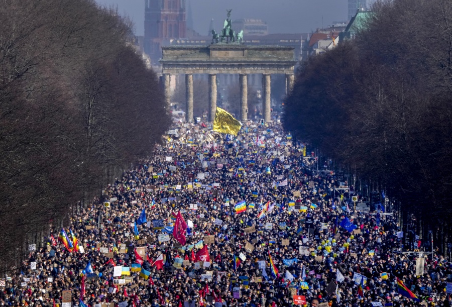 People walk down the bulevard 'Strasse des 17. Juni' ahead of a rally against Russia's invasion of Ukraine in Berlin, Germany, Sunday, Feb. 27, 2022.