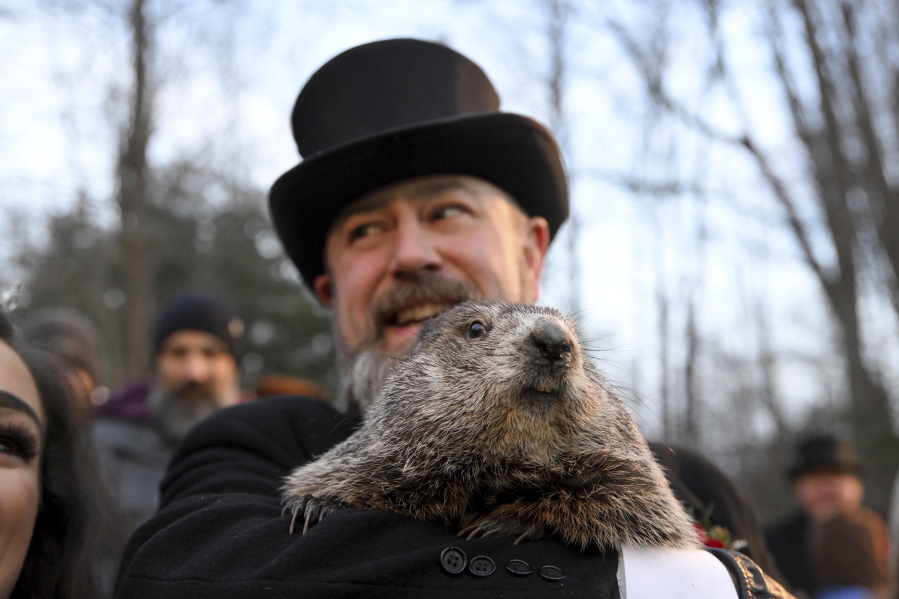 Groundhog Club handler A.J. Dereume holds Punxsutawney Phil, the weather prognosticating groundhog, during the 136th celebration of Groundhog Day on Gobbler's Knob in Punxsutawney, Pa., Wednesday, Feb. 2, 2022. Phil's handlers said that the groundhog has forecast six more weeks of winter.