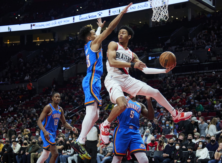 Portland Trail Blazers guard Anfernee Simons, right, looks to pass the ball as Oklahoma City Thunder guard Tre Mann defends during the first half of an NBA basketball game in Portland, Ore., Friday, Feb. 4, 2022.
