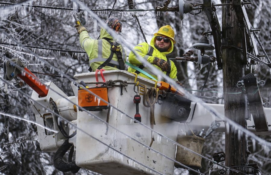Crews work to restore power to the Central Garden neighborhood of Memphis, Tenn., on Friday, Feb. 4, 2022. More than 120,000 customers were without power Friday afternoon in Shelby County, according to poweroutage.us, which tracks utility reports.