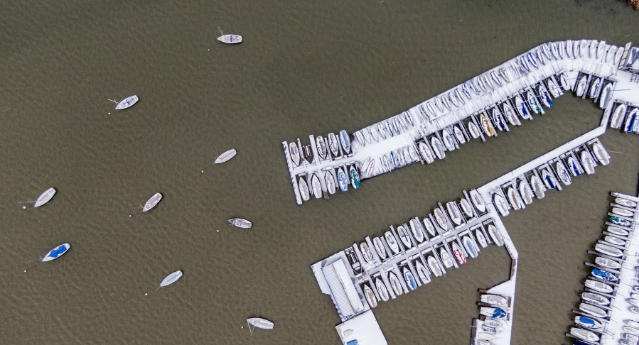 Boats are covered with ice and snow at White Rock Lake, Thursday, Feb. 3, 2022, in Dallas. More than 200,000 homes and businesses lost power across the U.S.