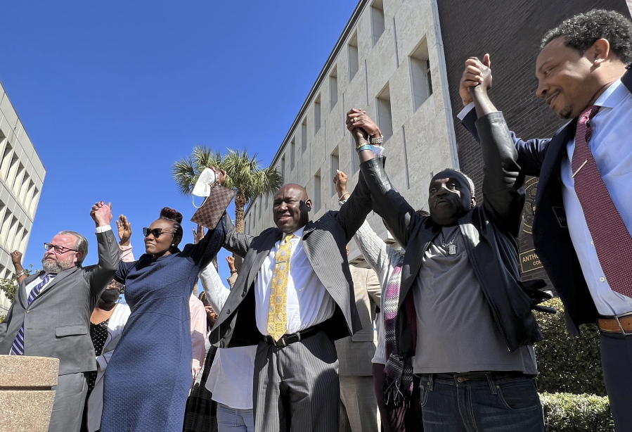 The family and attorneys of the Ahmaud Aubery raise their arms in victory after all three men were found guilty of hates crimes at the federal courthouse in Brunswick, Ga., on Tuesday, Feb. 22, 2022.   Greg McMichael, Travis McMichael and William "Roddie" Bryan, the three men convicted of murder in Arbery's fatal shooting have been found guilty of federal hate crimes.   (AP Photo/Lewis M.