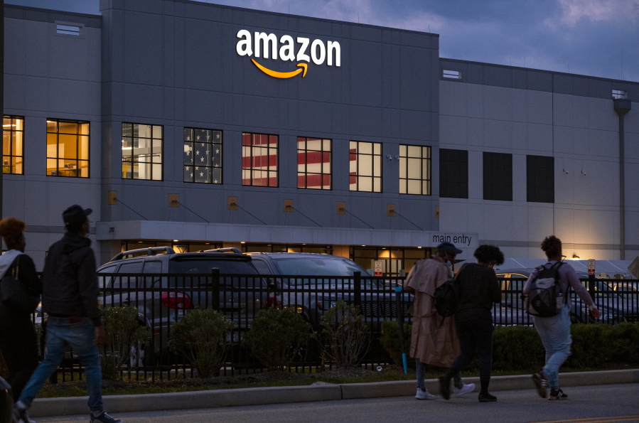 FILE - People arrive for work at the Amazon distribution center in the Staten Island borough of New York, Monday, Oct. 25, 2021. The battle to unionize Amazon workers is intensifying after labor officials officially set a date for an election in a New York City facility next month. The election, which will be held in-person, is slated for between March 25-30, confirmed the National Labor Relations Board Thursday, Feb. 17 2022.