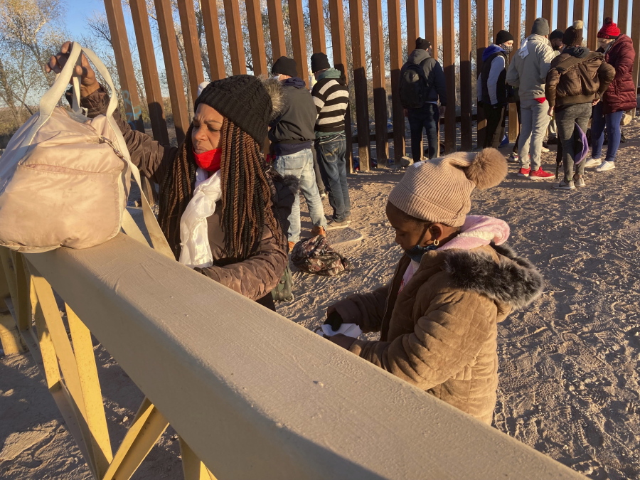 A Cuban woman and her daughter wait in line to be escorted to a Border Patrol van for processing in Yuma, Ariz., on Sunday hoping to remain in the United States to seek asylum.