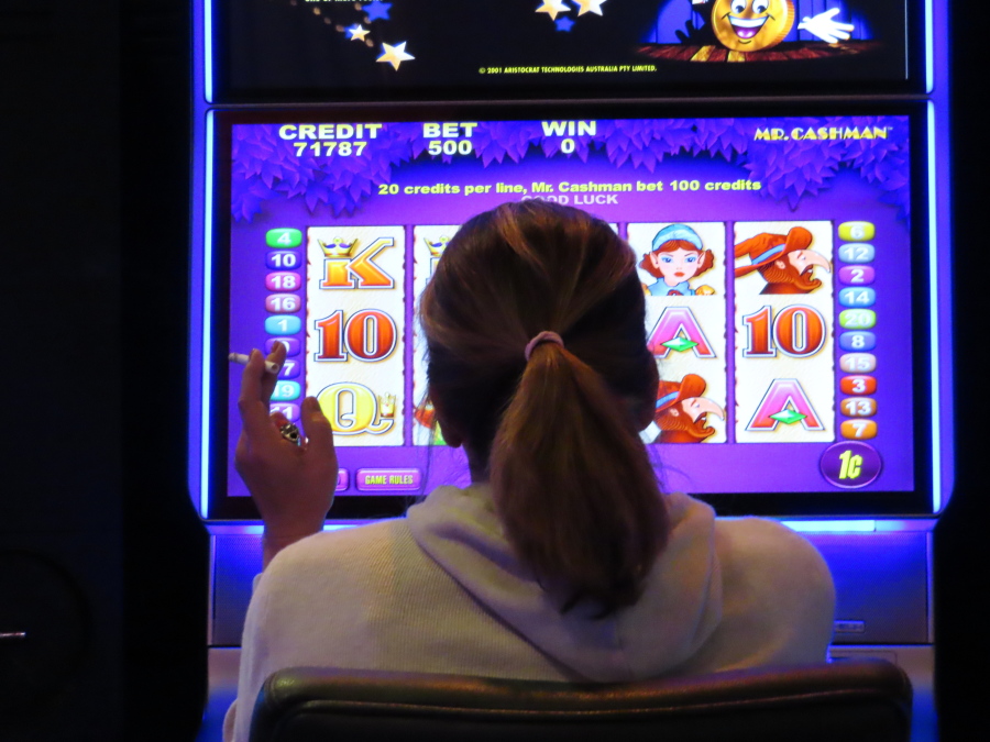 This Feb. 10, 2022 photo shows a gambler smoking while playing a slot machine at the Ocean Casino Resort in Atlantic City N.J. A report released Feb. 23, 2022 by the Casino Association of New Jersey says a proposed smoking ban at Atlantic City's casinos could lead to the loss of 2,500 casino jobs and almost 11 percent of the casinos' revenue.