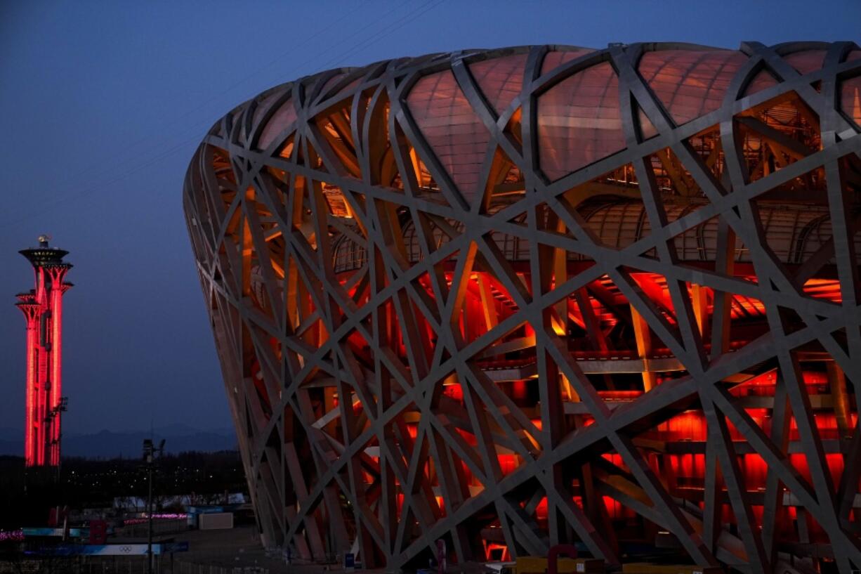 The National Stadium and the Beijing Olympic Tower are lit in red on the eve of the Chinese New Year ahead of the 2022 Winter Olympics, Jan. 31, 2022, in Beijing. The former site of the 2008 Summer Olympics, the Bird Nest will host the Winter Games opening cermony on Friday, Feb. 4, 2022. (AP Photo/Jae C.