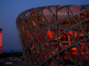 The National Stadium and the Beijing Olympic Tower are lit in red on the eve of the Chinese New Year ahead of the 2022 Winter Olympics, Jan. 31, 2022, in Beijing. The former site of the 2008 Summer Olympics, the Bird Nest will host the Winter Games opening cermony on Friday, Feb. 4, 2022. (AP Photo/Jae C.