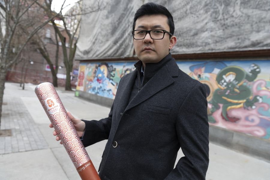 Kamalt?rk Yalqun holds the aluminium Olympics torch he carried at the 2008 Beijing Olympic Games at the age of 17, on Friday, Jan. 28, 2022, in Boston. The decade after the Games saw Beijing impose policies on his region of Xinjiang that split apart his family and Uyghur community. Today, he is an activist in the United States calling for a boycott of the 2022 Winter Games, which will see the Olympic flame returned to Beijing.