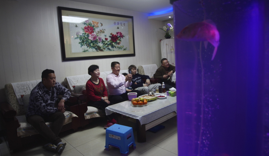 The family of Liu Wenbin, center, watches the opening ceremony of the Beijing Olympics on a television with his family at home in western Beijing on Friday, Feb. 4, 2022. Liu, a retiree from Beijing, was unable to see the event up close this year as tickets were only available to select groups owing to pandemic prevention measures. "As a Chinese person, I feel incomparably proud," Liu said. "Our great China really is no.