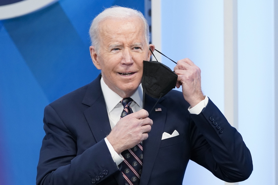 President Joe Biden removes his face mask to speak in the South Court Auditorium in the Eisenhower Executive Office Building on the White House complex, Tuesday, Feb. 22, 2022, in Washington.