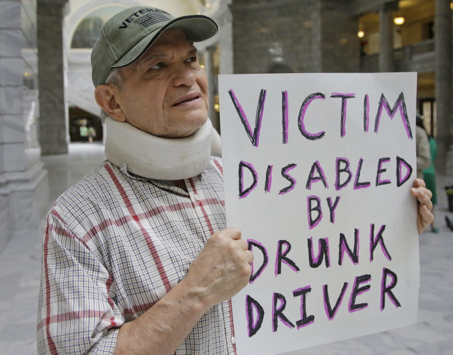 FILE -- In this March 17, 2017, file photo, Ed Staley holds a sign during a rally at the Utah State Capitol in Salt Lake City. Car crashes and traffic deaths decreased in Utah the after state enacted the strictest drunken driving laws in the nation. A study published, Friday, Feb. 11, 2022, by the National Highway Traffic Safety Administration suggests Utah's roads became safer after the state lower the drunken driving threshold to .05% blood-alcohol content.