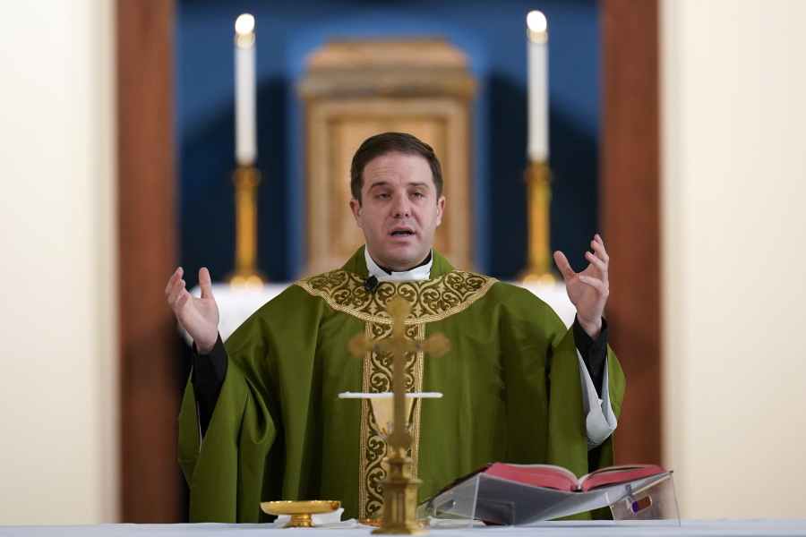 Father Matthew Hood celebrates Mass at Our Lady of the Rosary church Friday in Detroit. Hood was one of many whose baptism was invalid because of incorrect wording.