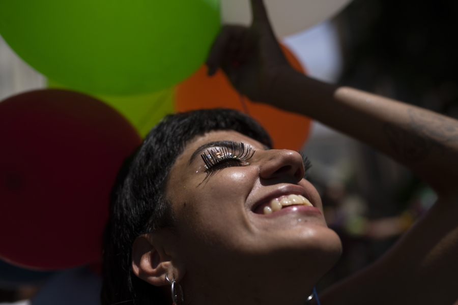 A reveler smiles during an unofficial carnival block party referred to as "blocos", in Rio de Janeiro, Brazil, Saturday, Feb. 26, 2022. City Hall banned all blocos, the tightly packed street parties attended by those who cannot or don't want to buy pricey tickets for the official parade at the Sambadrome, due to a wave of the Omicron variant.