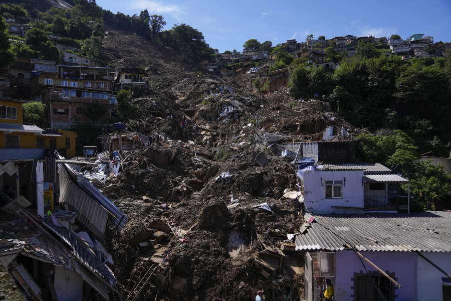 The path of a mudslide marks a hillside filled with homes in Petropolis, Brazil, Thursday, Feb. 17, 2022. Deadly floods and mudslides swept away homes and cars, but even as families prepared to bury their dead, it was unclear how many bodies remained trapped in the mud.