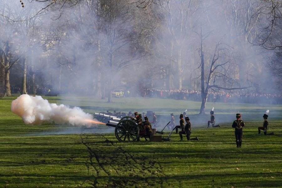 Fire shrouds the scene as The King's Troop Royal Horse Artillery fire gun salutes to mark the 70th anniversary of the accession to the throne of Britain's Queen Elizabeth, in Green Park beside Buckingham Palace, London, Monday, Feb. 7, 2022. Queen Elizabeth II acceded to the throne on the death of her father King George VI on Feb. 6, 1952.