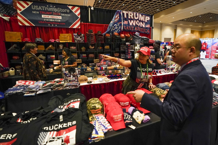 Conference attendees shop for merchandise at a trade show at the Conservative Political Action Conference (CPAC) Friday, Feb. 25, 2022, in Orlando, Fla.