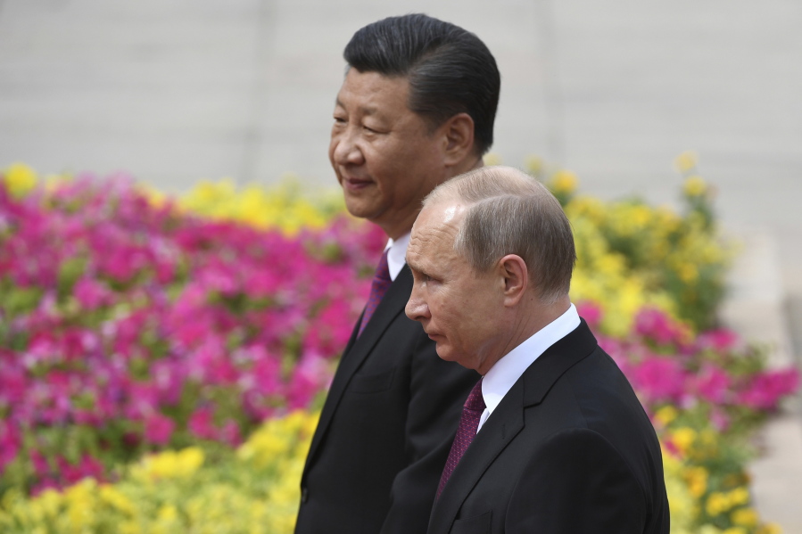 FILE - Russia's President Vladimir Putin, right, reviews a military honor guard with Chinese President Xi Jinping during a welcoming ceremony outside the Great Hall of the People in Beijing, June 8, 2018. Russian President Putin on Friday, Feb. 4, 2022, arrived in Beijing for the opening of the Winter Olympic Games and talks with his Chinese counterpart Xi Jinping, as the two leaders look to project themselves as a counterweight to the U.S. and its allies.