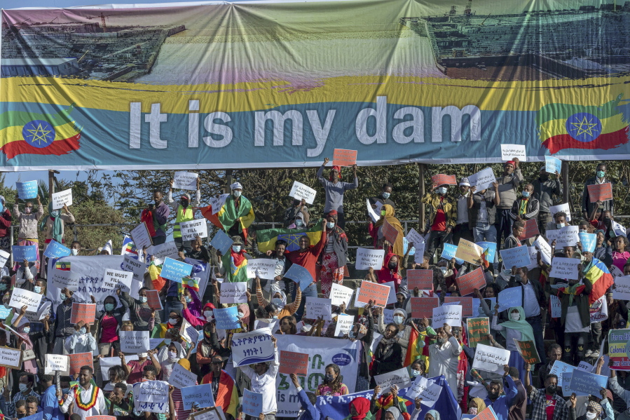 FILE - Ethiopians protest against international pressure on the government over the conflict in Tigray, below a banner referring to The Grand Ethiopian Renaissance Dam, at a demonstration organised by the city mayor's office held at a stadium in the capital Addis Ababa, Ethiopia, on May 30, 2021. Ethiopia started on Sunday, Feb 20, 2022 generating electricity from the controversial mega-dam that is being built on the Blue Nile, when one of the 13 turbines of the dam started power generation in an event officiated by Prime Minister Abiy Ahmed.
