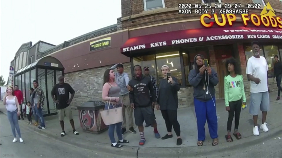 FILE - In this image from a police body camera, bystanders, including Alyssa Funari, filming at left; Charles McMillan, center left in light colored shorts; Christopher Martin, center in gray, with hand on head; Donald Williams, center in shorts; Genevieve Hansen, filming, fourth from right; Darnella Frazier, filming, third from right, witness as then Minneapolis police officer Derek Chauvin pressed his knee on George Floyd's neck for several minutes, killing Floyd on May 25, 2020, in Minneapolis. Frazier, who recorded the widely seen video of Floyd's killing, began crying Monday, Feb. 14, as she started testifying in the federal trial of three former Minneapolis police officers who are charged with violating the Black man's civil rights, prompting the judge to take a quick, unexpected break.