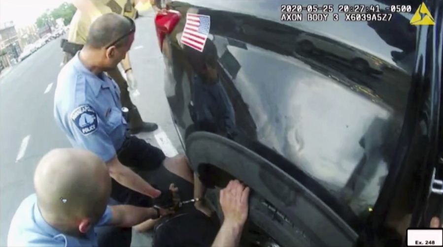 FILE - In this image from police body camera video shown as evidence in court, paramedics arrive as Minneapolis police officers, including Derick Chauvin, second from left, and J. Alexander Kueng restrain George Floyd in Minneapolis, on May 25, 2020. Former police officers Tou Thao, Kueng and Thomas Lane are on trial in federal court accused of violating Floyd's civil rights as fellow Officer Derek Chauvin killed him.
