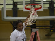 Senior Aniyah Hampton celebrates after cutting down the net after Hudson's Bay beat Woodland 60-18 to clinch the 2A Greater St. Helens League girls basketball title on Thursday, Feb. 3, 2022.