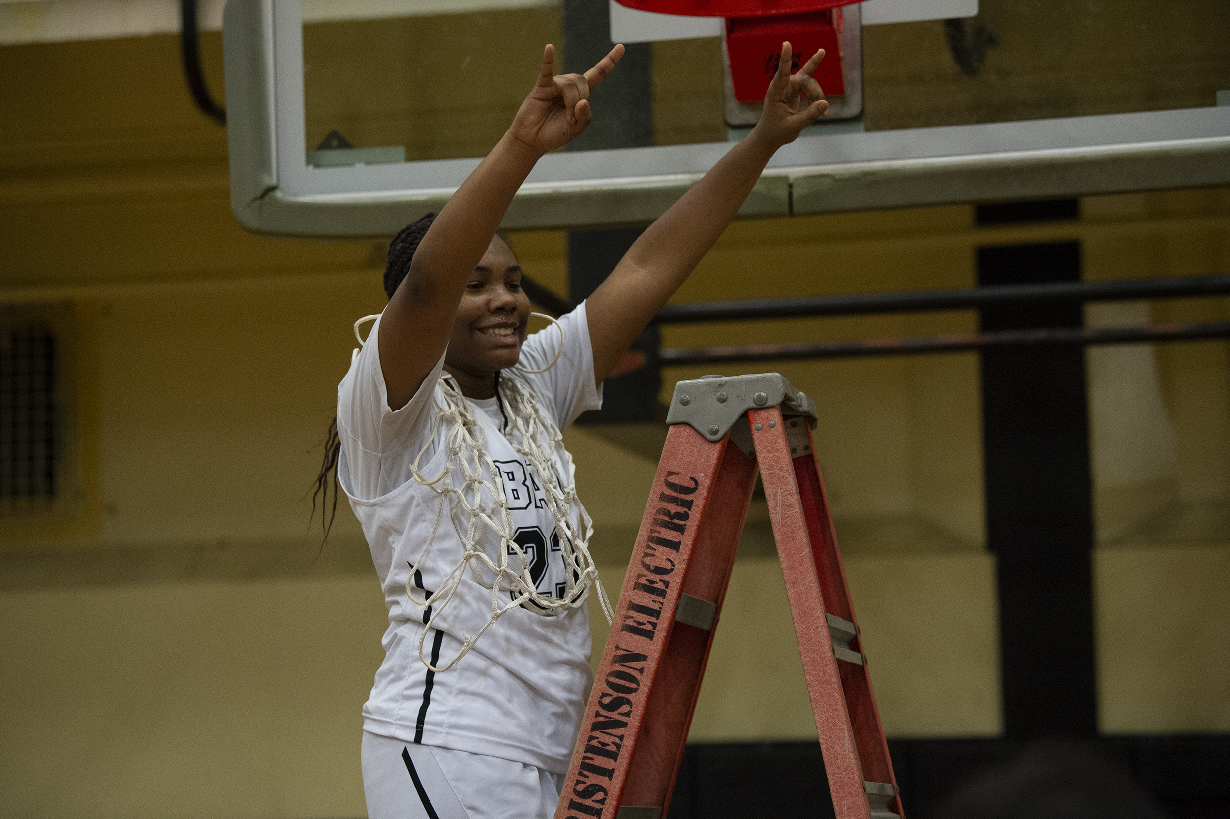 Senior Aniyah Hampton celebrates after cutting down the net after Hudson's Bay beat Woodland 60-18 to clinch the 2A Greater St. Helens League girls bassketball title on Thursday, Feb. 3, 2022.